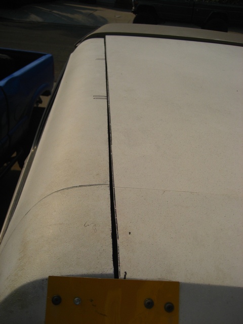1989 Ford Bronco - A close-up view of a vehicle's roof seam, with a blue truck visible to the left.