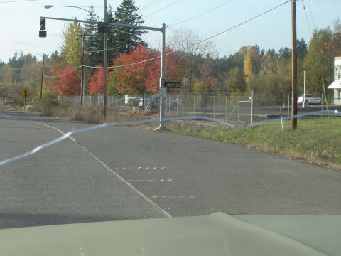 1978 Ford Bronco - A view of an intersection with colorful autumn foliage and a distant silver car.
