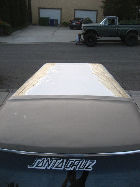 1989 Ford Bronco - The roof of a car shows a patch of white primer, with a "SANTA CRUZ" sticker visible below.