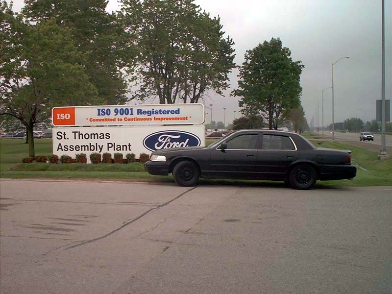 Black 2000 Ford Crown Victoria parked by a sign for St. Thomas Assembly Plant