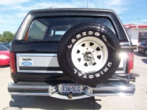 1986 Ford Bronco - The rear of a black Ford Bronco is shown, a spare tire and a license plate.