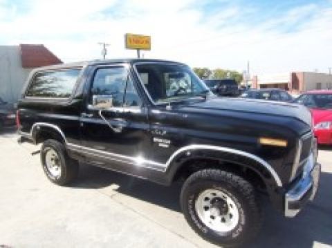 1986 Ford Bronco - This 1986 Ford Bronco is parked on a paved surface under a blue sky.