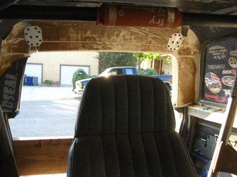1989 Ford Bronco - Custom interior of a 1989 Ford Bronco, a roll cage and various stickers on the interior panels.