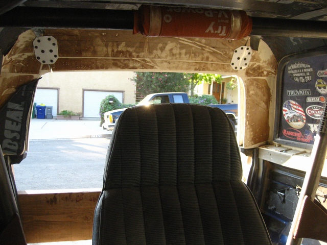 Muddy stripped 4x4 interior with roll bar padding, black seat and sticker-covered window