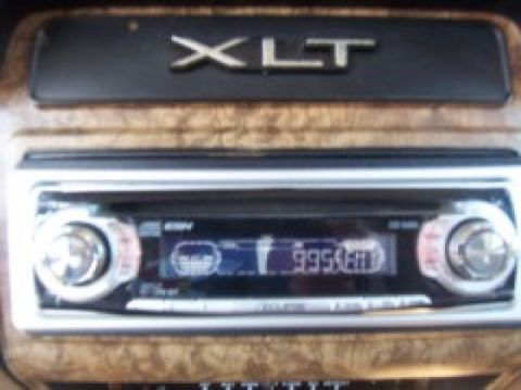 1986 Ford Bronco - The dashboard features an 'XLT' badge and an aftermarket car stereo with a digital display.