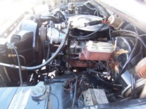 1986 Ford Bronco - A close-up view of a vehicle's engine bay, showing various components and wiring.