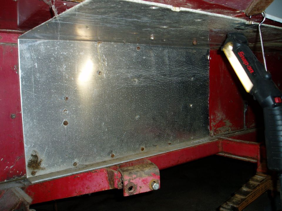 Metal panel bolted to red frame, with a Snap-on work light illuminating it