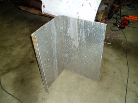 2000 Ford E350 - A metal panel is shown in a garage setting with tools and a vehicle part visible.