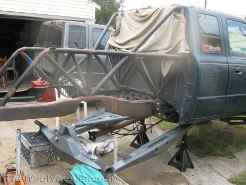1968 Ford Mustang - Custom off-road truck chassis undergoing modifications with a roll cage and suspension work.