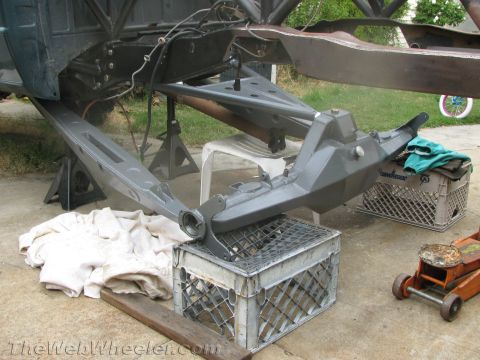 1968 Ford Mustang - The underside of a vehicle is shown, with suspension components and frame elements visible while on jack stands.