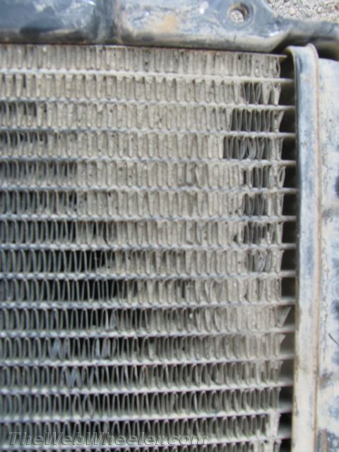 1987 Suzuki Samurai - Radiator core showing bent fins and accumulated dirt.