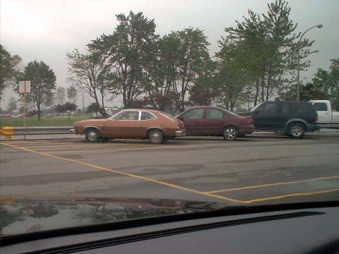 2000 Ford Crown Victoria - A brown coupe is parked in a lot with other vehicles visible.