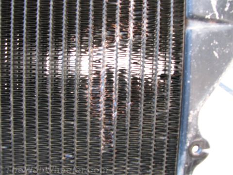1987 Suzuki Samurai - Radiator grille shows damage and bent fins, indicating a need for repair or replacement.