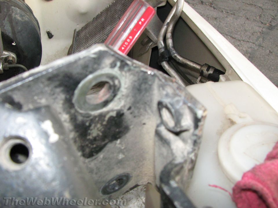 Close-up of engine bay with metal bracket, radiator, and fluid reservoir