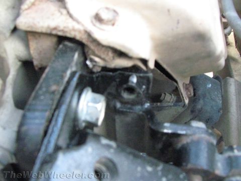 1987 Suzuki Samurai - A close-up view of a vehicle's engine mount bracket, showing mechanical components and fasteners.