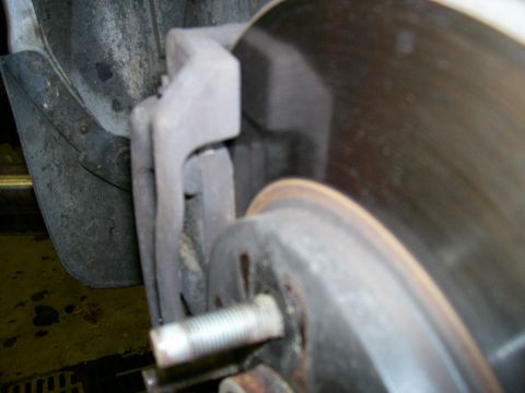 2001 Ford Crown Victoria - Close-up view of a vehicle's brake caliper and rotor assembly.