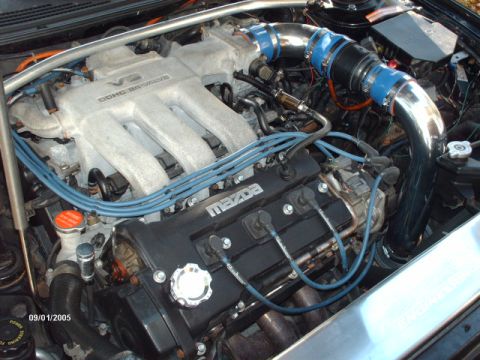 1995 Ford Probe - The engine bay features a V6 engine with visible 'Mazda' branding on the valve cover and custom intake piping.