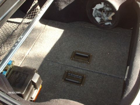 1995 Ford Probe - Interior view of a car's trunk, showing carpet, handles, and a speaker enclosure.