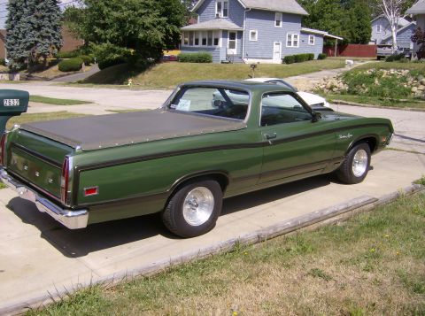 1970 Ford Ranchero - A green 1970 Ford Ranchero pickup truck is parked on a driveway in front of a house.