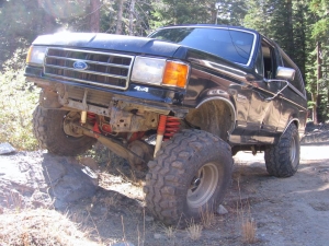 1986 Ford Bronco - This 1986 Ford Bronco is shown navigating an off-road trail with one wheel lifted.