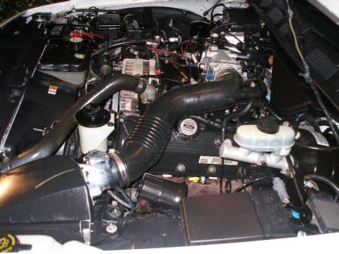2001 Ford Crown Victoria - Engine bay of a 2001 Ford Crown Victoria, showing the air intake system and brake fluid reservoir.