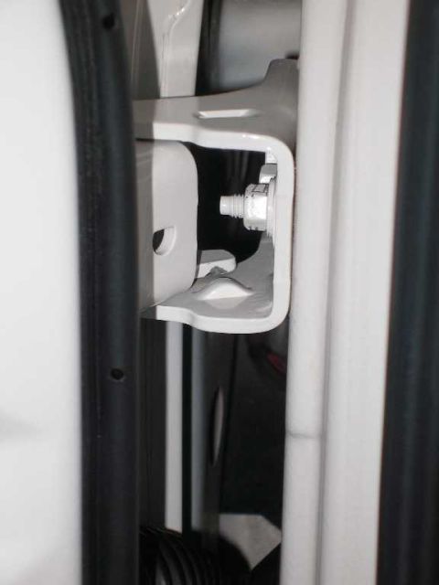 2001 Ford Crown Victoria - Detail shot of the door hinge assembly and surrounding frame, showing mechanical components.