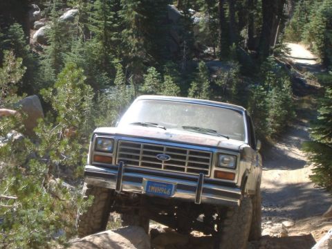1985 Ford Bronco - This 1985 Ford Bronco navigates a challenging rocky path through a wooded area.