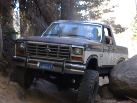 1985 Ford Bronco - This Ford Bronco navigates a rocky trail with its front end angled towards the camera.