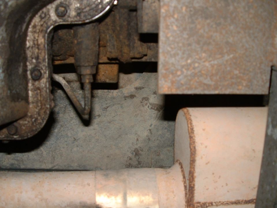 Undercarriage view of exhaust pipe and rusty metal components