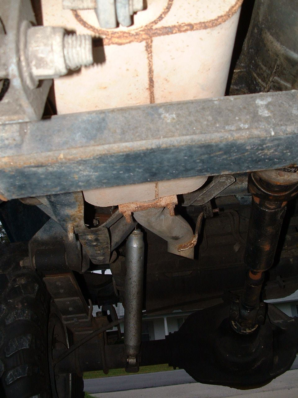 Undercarriage view showing suspension, exhaust, and driveshaft. No specific vehicle identified