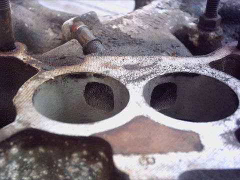 1979 Ford LTD - Close-up view of intake manifold ports, showing significant carbon deposits and wear.