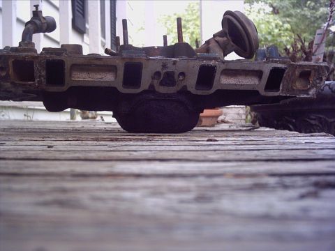 1979 Ford LTD - An intake manifold is shown from a low angle on a wooden surface.