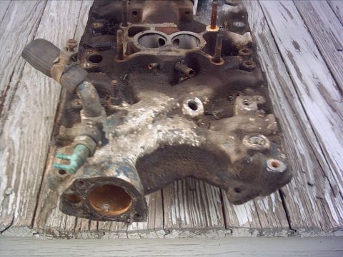 1979 Ford LTD - A used intake manifold, likely from a V8 engine, is shown resting on a wooden surface.