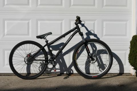 1997 Ford Probe - A black mountain bike with disc brakes and knobby tires is shown against a garage door.