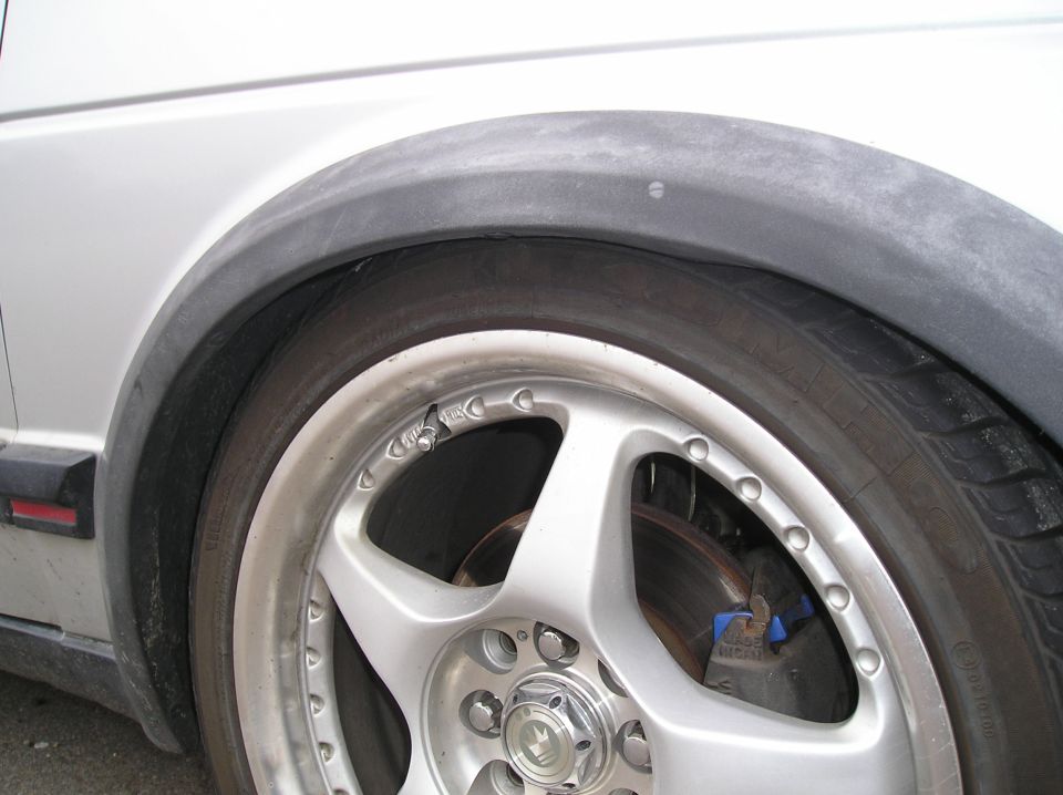 Close-up of a car's silver alloy wheel and black fender flare