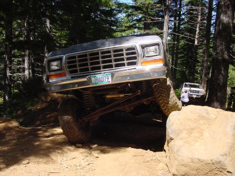1979 Ford Bronco - 1979 Ford Bronco tackling a challenging off-road course with a second Bronco in the background.
