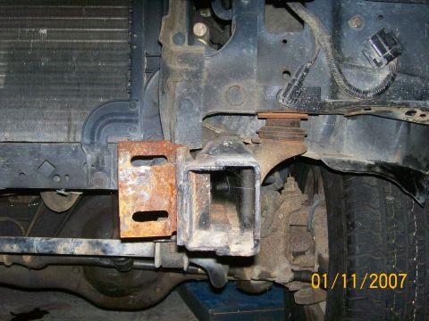 1996 Ford Bronco - Close-up view of a vehicle's front frame and tow hitch receiver, showing signs of rust and wear.