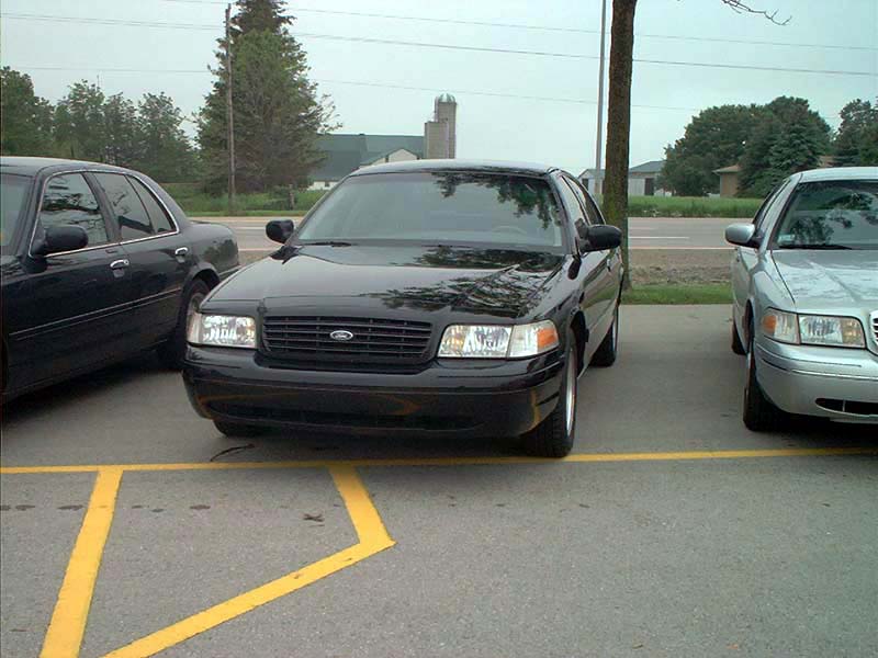 Black 2000 Ford Crown Victoria parked next to another car