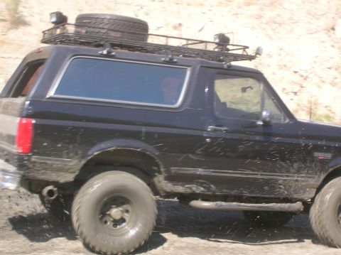 1985 Ford Bronco - This black Ford Bronco is equipped for off-road adventures with a roof rack and spare tire.