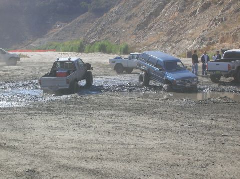 1985 Ford Bronco - Multiple off-road vehicles are stuck in the mud during an outing.