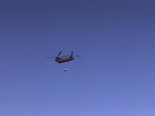 1988 Ford Bronco - A Chinook helicopter transports a payload under a clear blue sky.