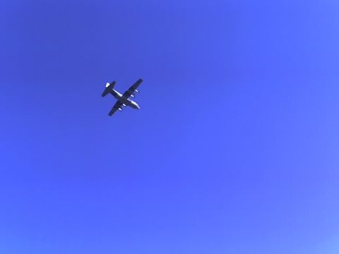 1988 Ford Bronco - A twin-engine turboprop aircraft is seen in flight against a bright blue sky.
