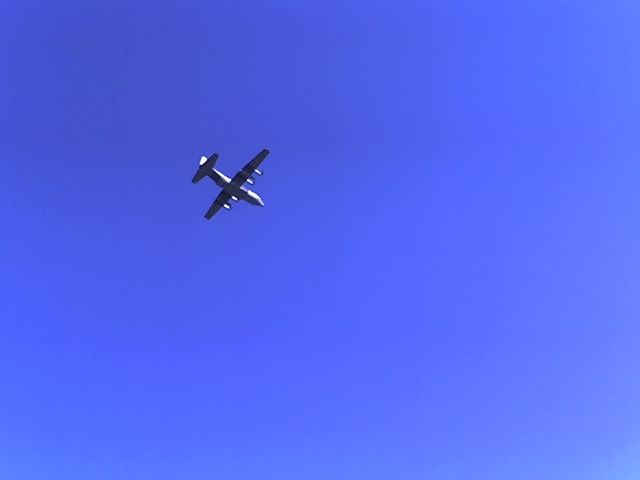 twin-engine turboprop airplane flying in clear blue sky