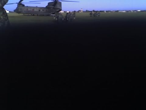 1988 Ford Bronco - A military helicopter is parked on a field with soldiers standing around it.