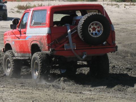 1987 Ford Bronco - 1987 Ford Bronco navigating a muddy off-road course.