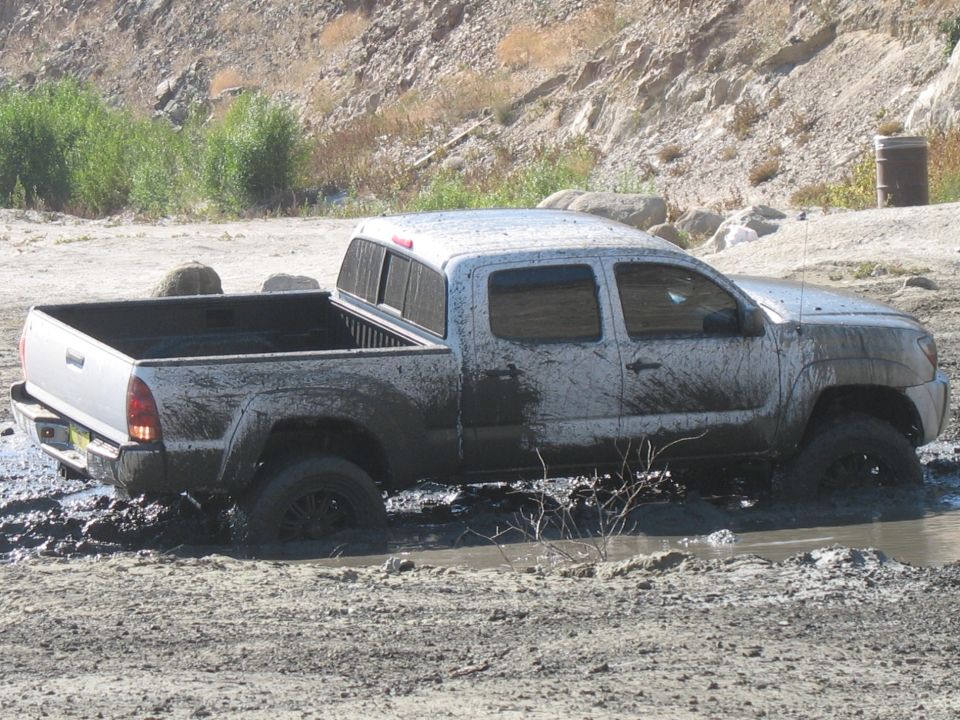 Pickup truck stuck in mud. The page claims it is a 1987 Ford Bronco