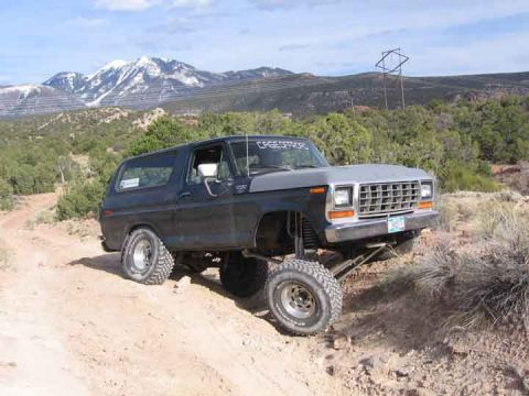 1979 Ford Bronco - This lifted 1978 Ford Bronco navigates a rocky, off-road path with mountains in the background.