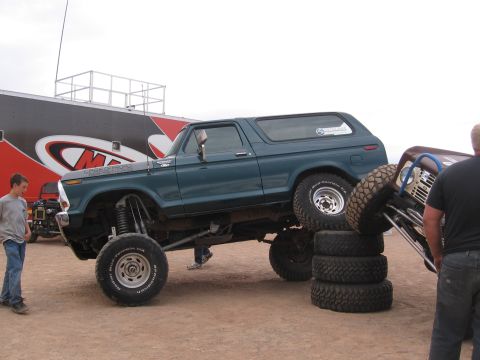 1979 Ford Bronco - A modified 1978 Ford Bronco is elevated on a stack of tires, with another off-road vehicle nearby.