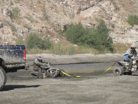 1987 Ford Bronco - Truck helps ATV stuck in mud. Two ATVs and one truck are in the scene.