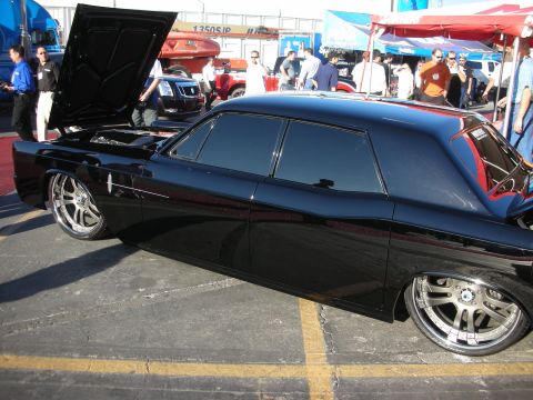 1998 Ford Crown Victoria - Side profile of a slammed black Lincoln Continental sedan with the hood up and chrome multi-spoke wheels.